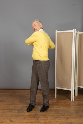 Front view of an old man exercising by making rotation