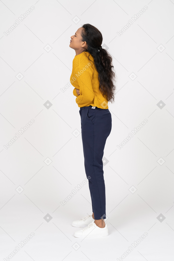 Side view of a girl in casual clothes suffering from stomachache