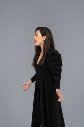 Side view of a singing young lady in a black dress