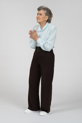 Elderly lady standing with her hands folded