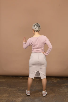Rear view of a woman in casual clothes showing stop gesture