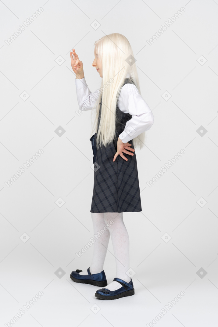 Side view of a schoolgirl making okay sign