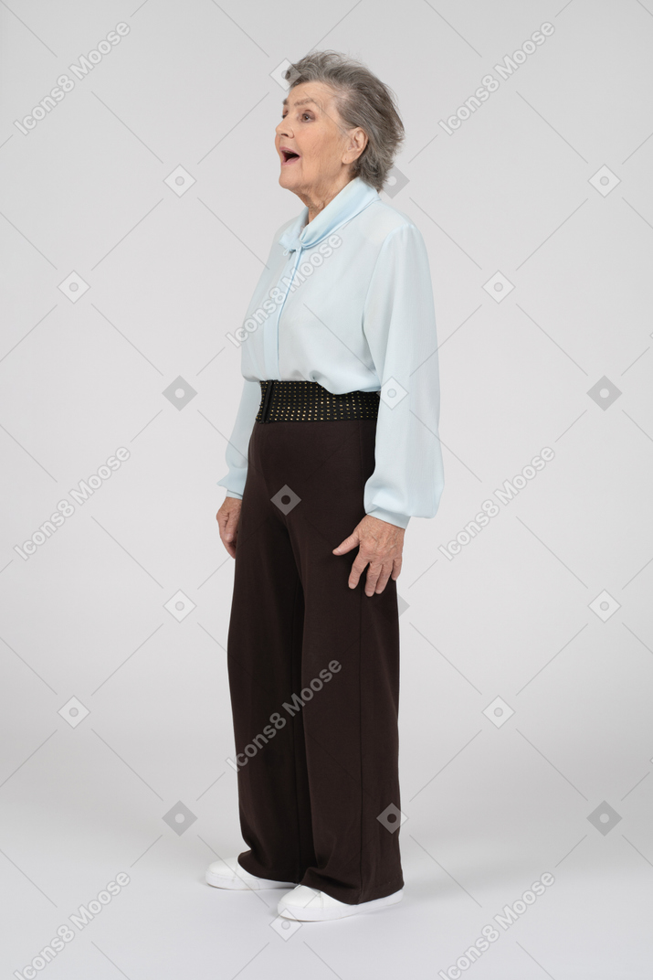 Vista laterale di una donna anziana che sembra piacevolmente sorpresa