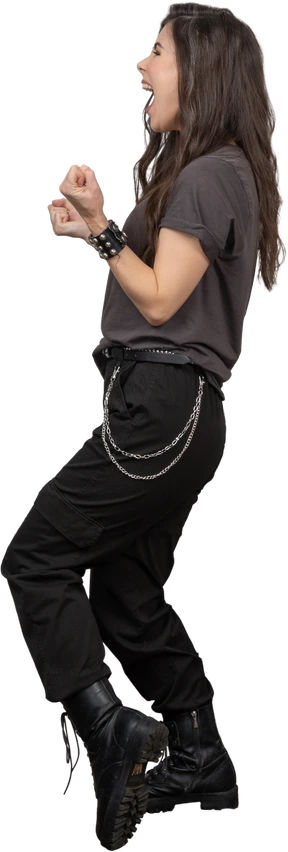 Side view of a happy female rocker clenching fists
