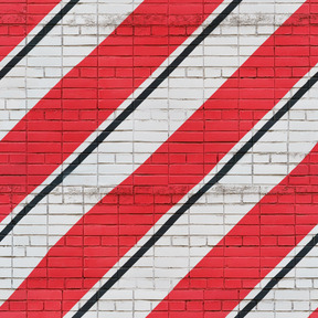 Mur de briques blanches avec des rayures rouges et noires