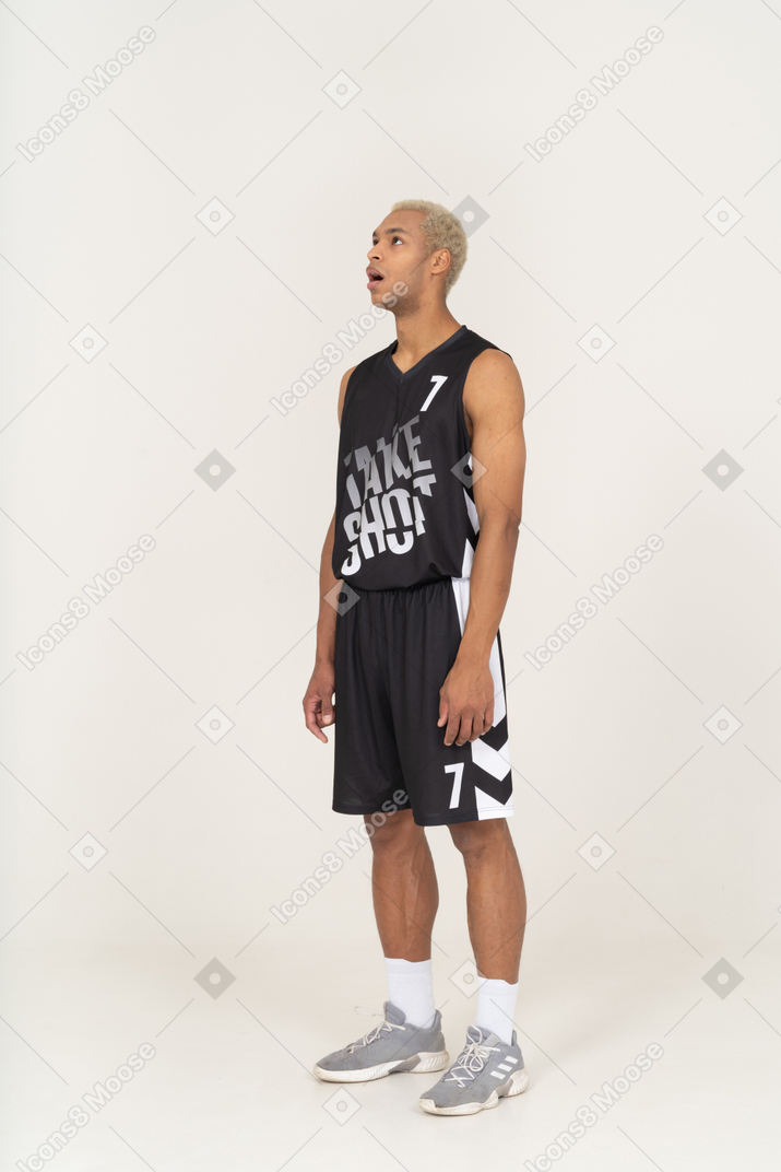 Vue de trois quarts d'un jeune joueur de basket-ball haletant