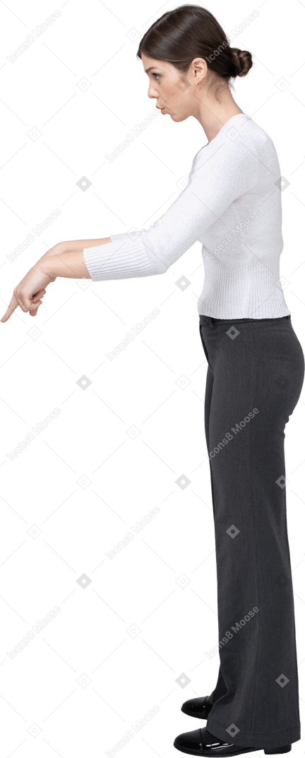 Vista laterale di una giovane donna in abiti casual che punta con un dito