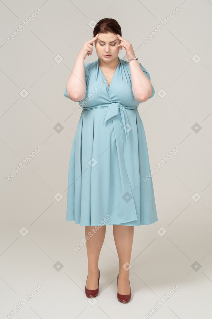 一个穿蓝色连衣裙的女人摸头的前视图