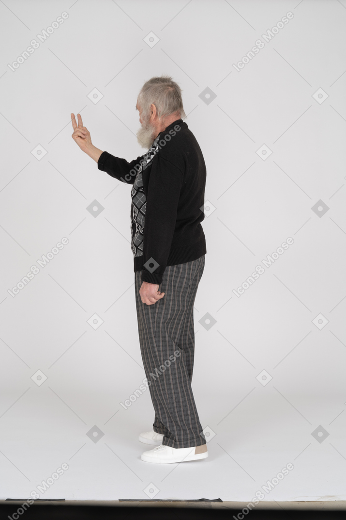 Вид сзади на старика, показывающего два пальца