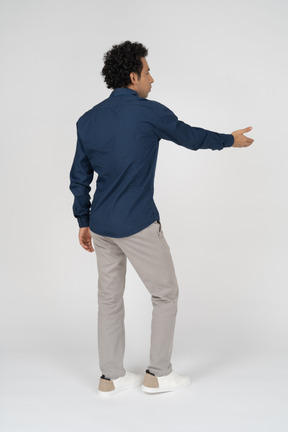 Vista traseira de um homem com roupas casuais apontando com a mão
