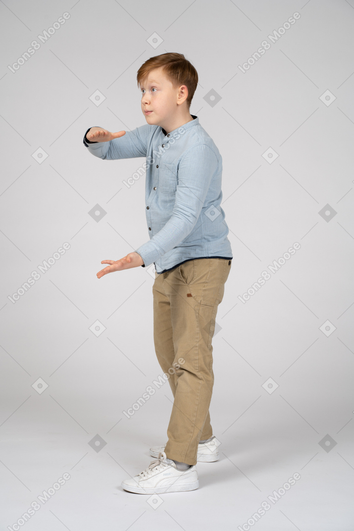 Side view of a cute boy showing size of something