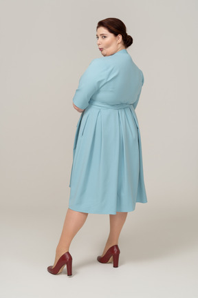 Rear view of a woman in blue dress making faces