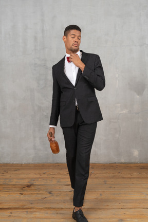 Young man walking and adjusting his bowtie