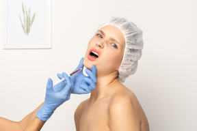 Mujer sintiendo dolor durante la inyección de botox