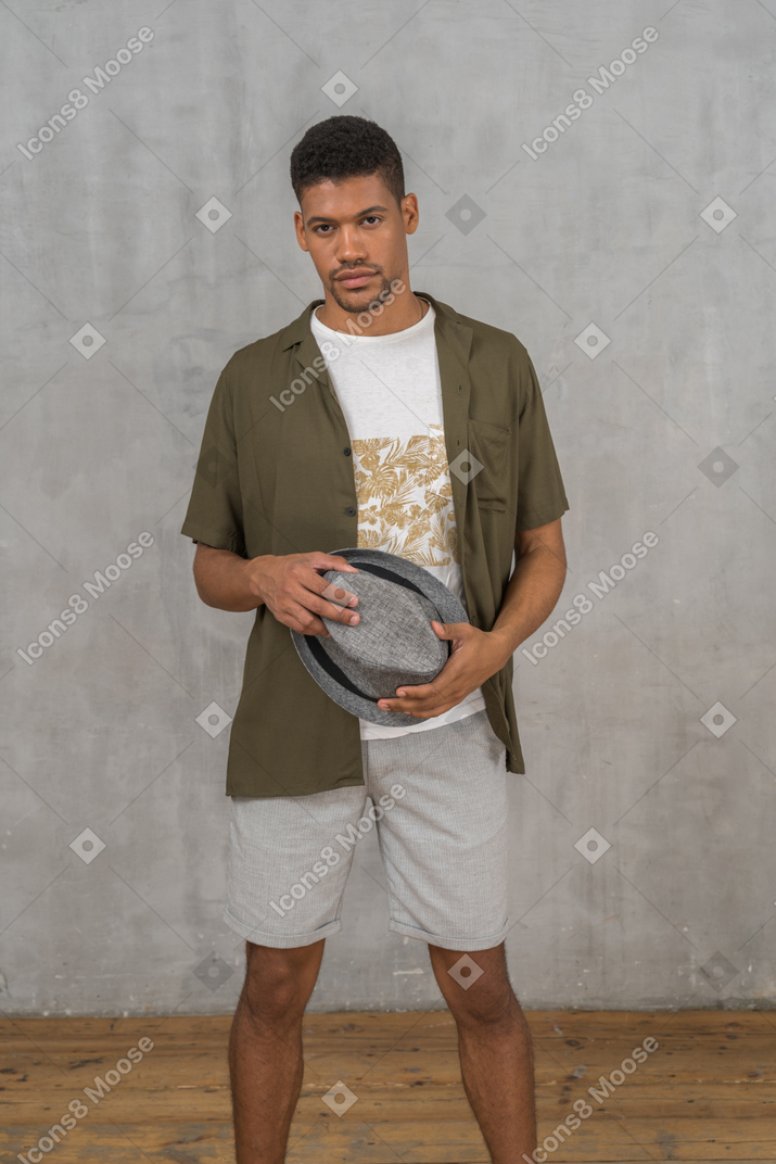 Man in casual clothes holding hat