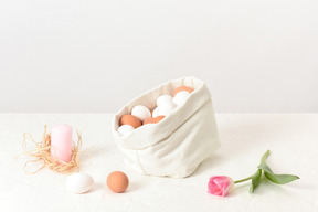 Bolsa de lino con unos huevos, una vela y un tulipán