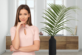 A woman standing next to a potted plant