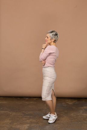 Mujer pensativa en ropa casual de pie en el perfil
