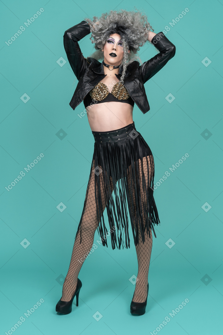 Drag queen en traje negro levantando el cabello