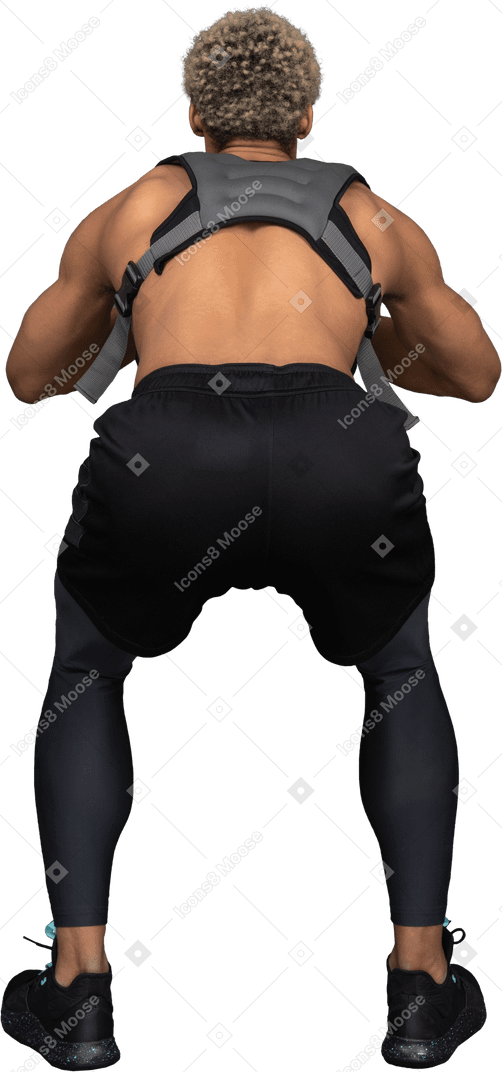 Vista traseira de um homem afro agachado sem camisa