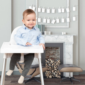 Heureux petit garçon assis dans une chaise haute