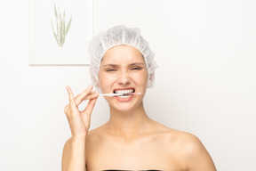 Woman holding syringe with her teeth