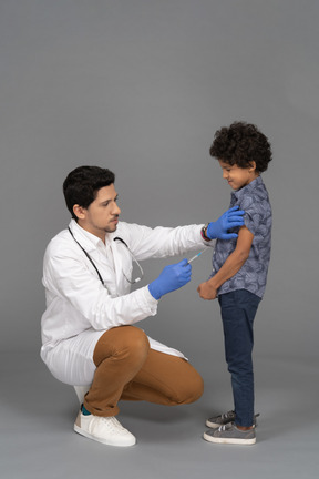 Médico fazendo uma injeção no menino