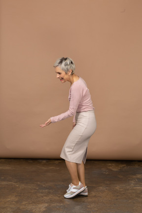Vista lateral de uma mulher com roupas casuais fazendo gesto de boas-vindas