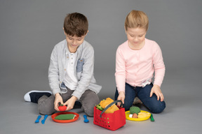 Crianças brincando com brinquedos de comida