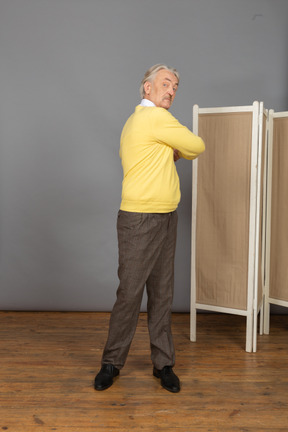 Vista frontal de un anciano haciendo ejercicio haciendo rotación