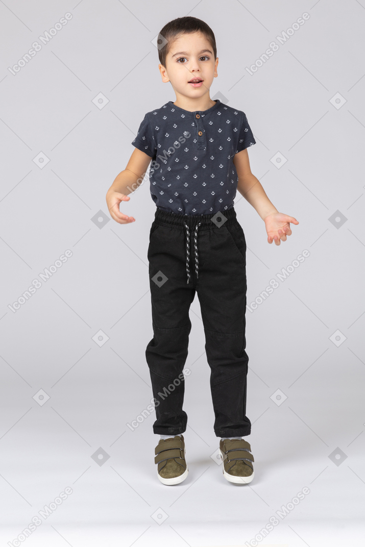 Front view of a cute boy looking at camera and gesturing