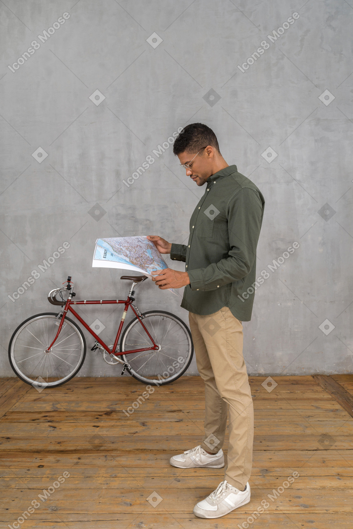 Vista lateral de un hombre examinando un mapa