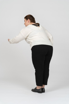 Plump woman in casual clothes posing