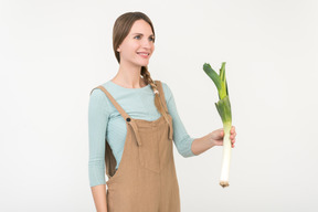 Young woman holding leek onion