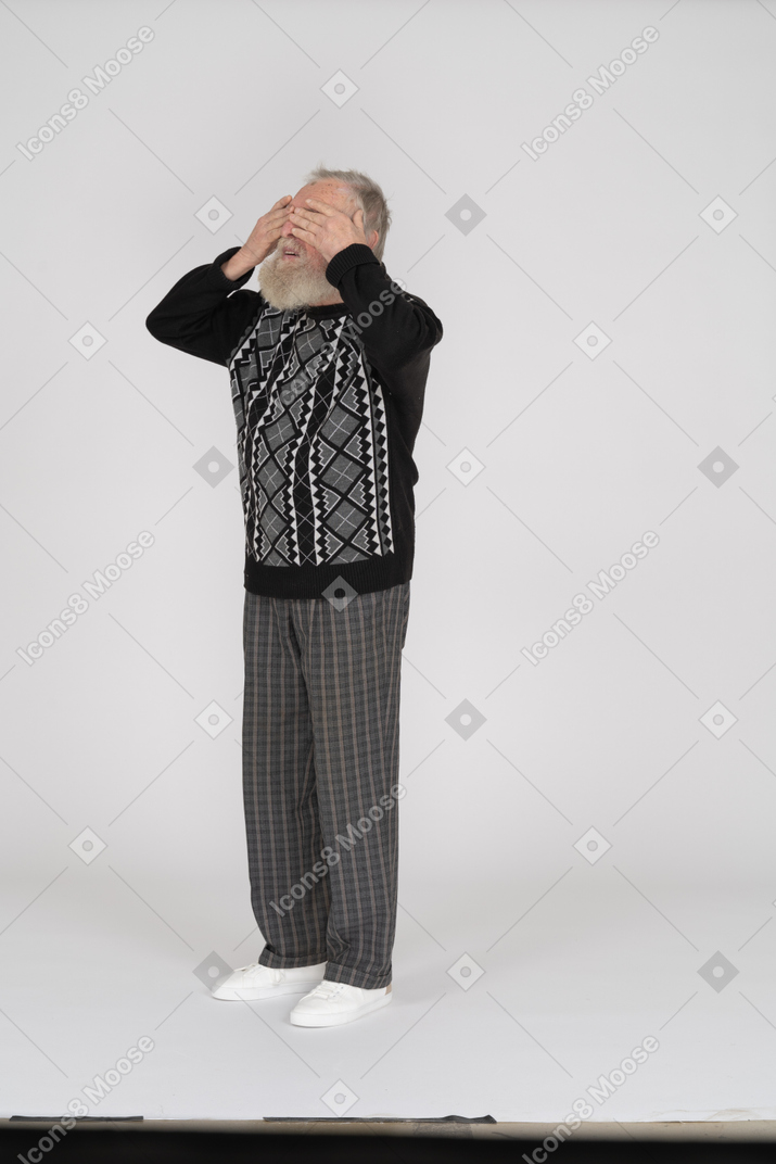 Old man covering eyes with hands