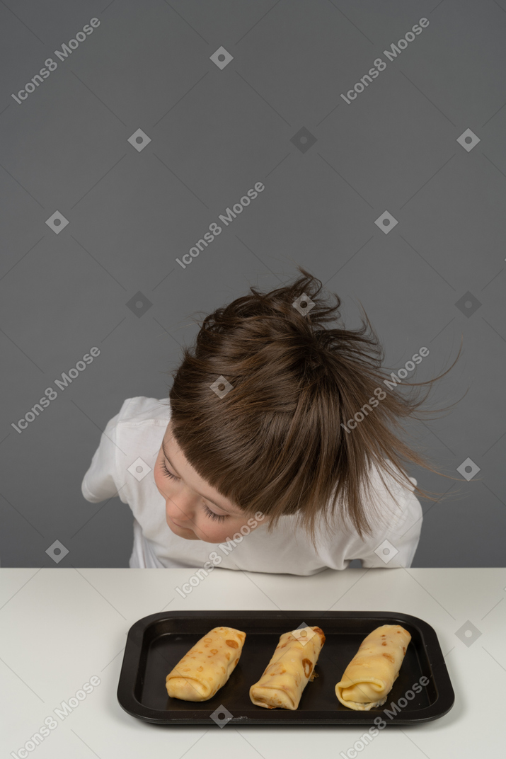 Little boy shaking his head in front of a food tray