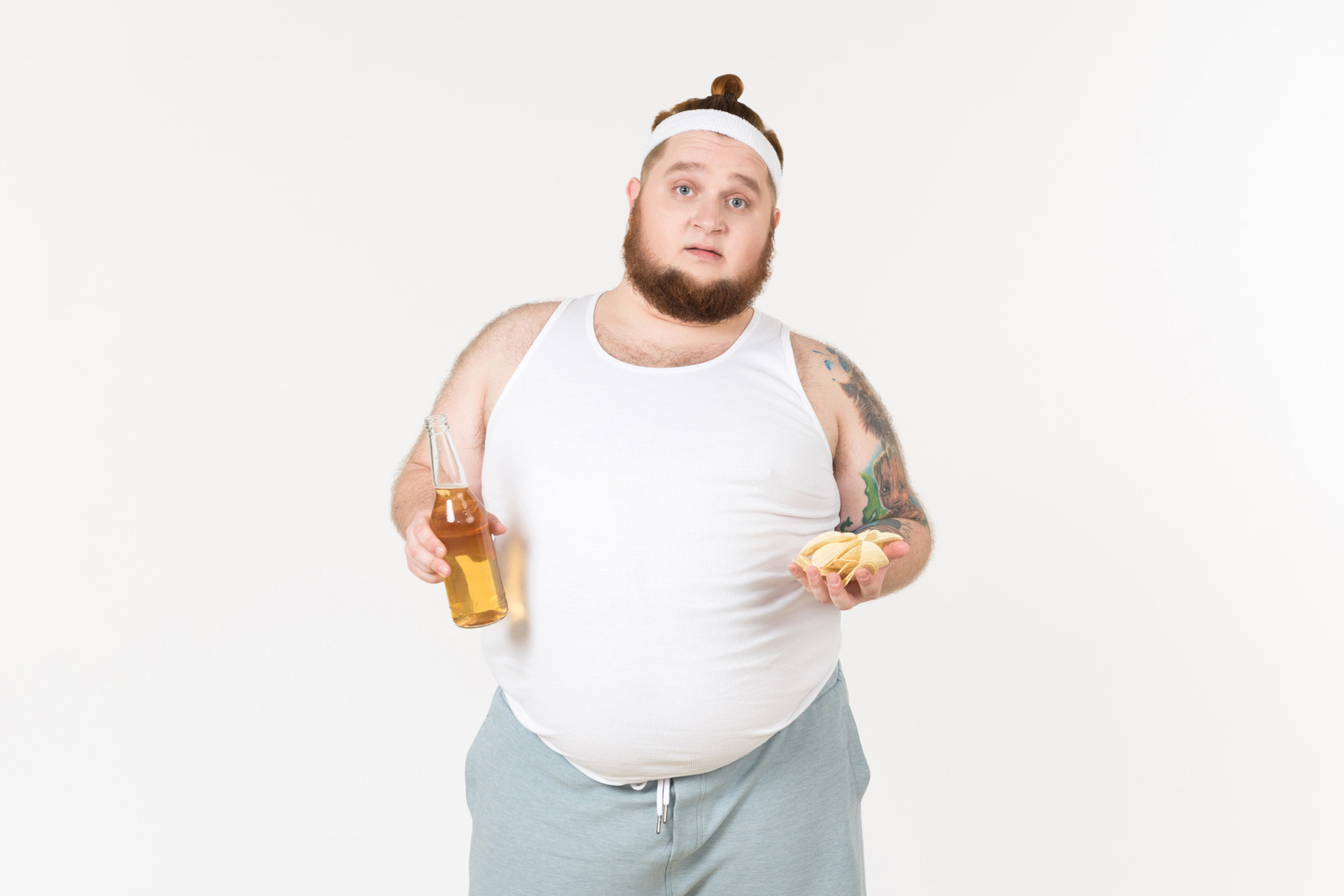 A fat man in sportswear with bottle of beer and handful of chips