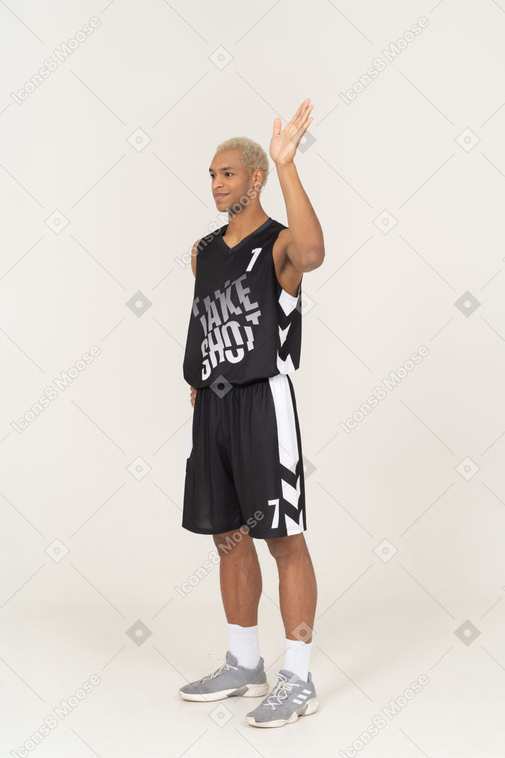 Three-quarter view of a young male basketball player raising hand