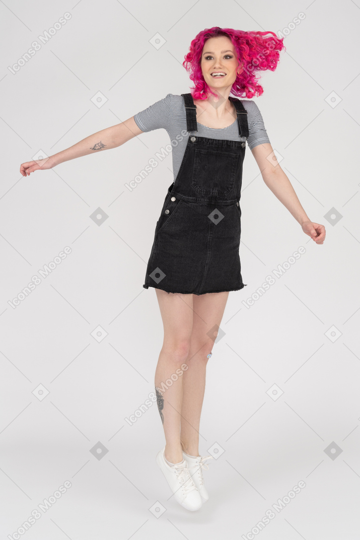 Adolescente feliz de cabelos rosa pulando