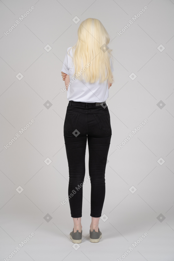 Back view of a young blonde girl feeling cold