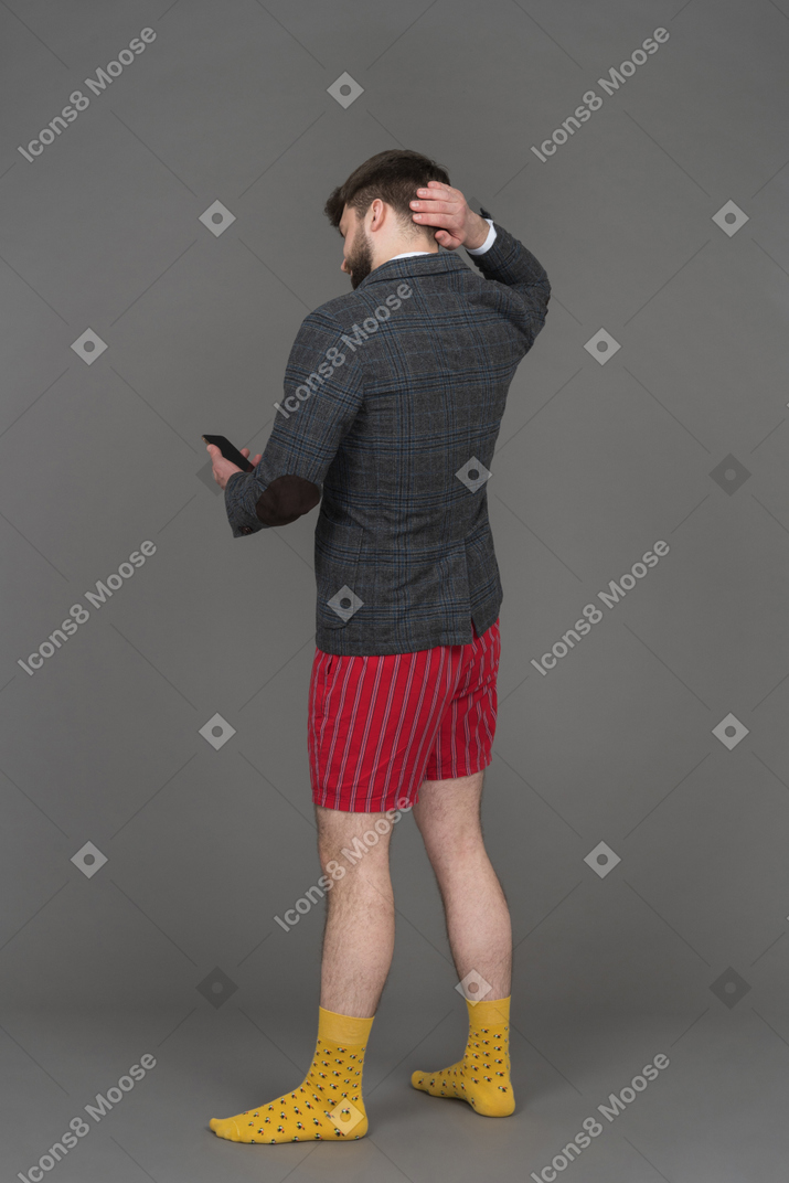 Office worker scratching his head while using mobile