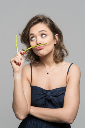 Retrato de una chica divertida con espárragos