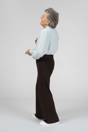 Three-quarter back view of an old woman laughing