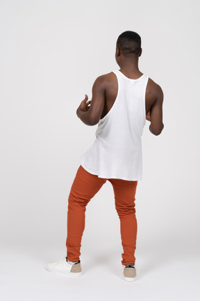 Back view of black man standing with his arms bent