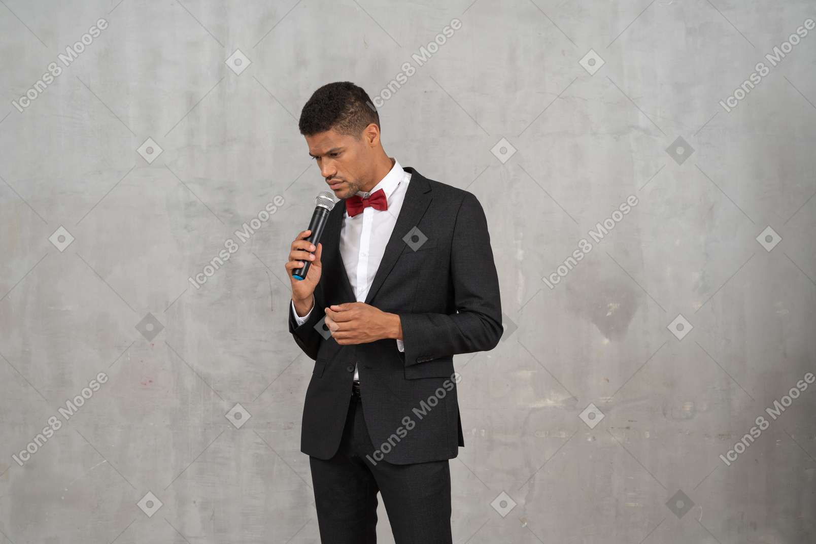 Uomo cupo in abito nero con in mano un microfono