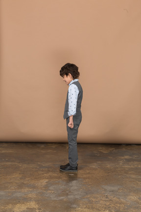 プロファイルに立っているスーツの少年