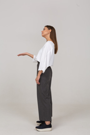 Side view of a young lady in office clothing asking for something