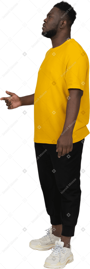 Three-quarter view of a thoughtful young dark-skinned man in yellow t-shirt raising hand