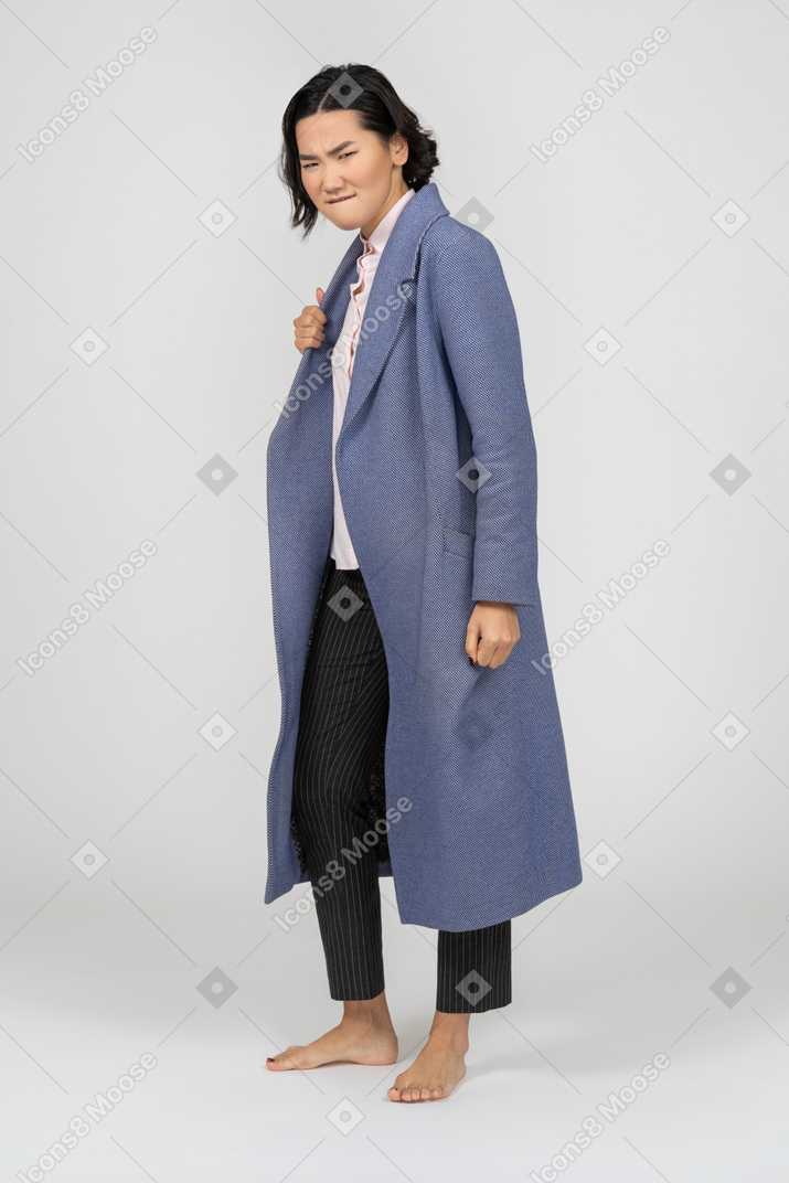 Angry woman in coat biting her lip