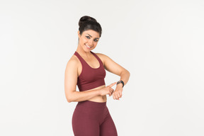 Indian girl in sporstwear checking fitness tracker